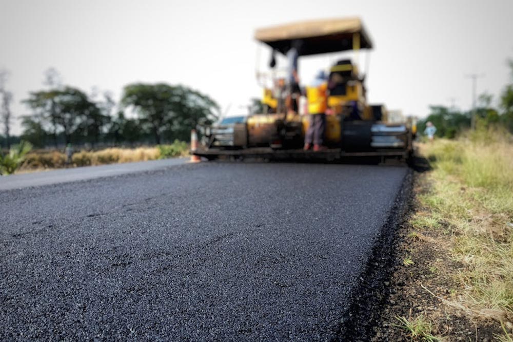 Contractor filling cracks in asphalt pavement