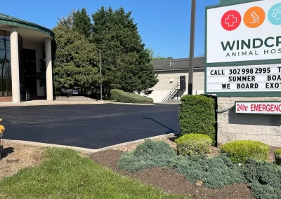 Windcrest Animal Hospital building and sign with a 24hr emergency notice by a driveway and a fire hydrant.